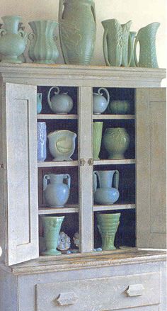 an old china cabinet with many vases on it