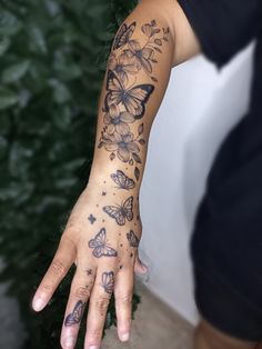 a woman's hand with butterfly tattoos on it