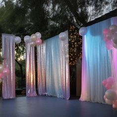 an outdoor event with balloons and curtains