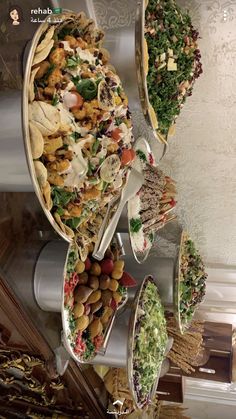 several platters filled with different types of food on top of each other in front of a white wall