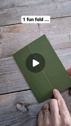 someone is holding an open book with a video playing on the page and then flipping it over