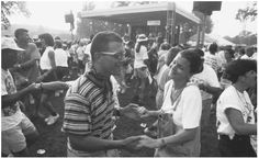 a man standing next to a woman in front of a crowd at a music festival