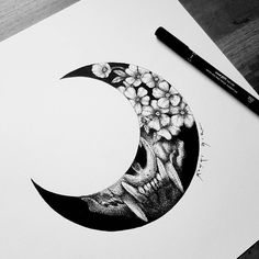 a black and white drawing of a half moon with flowers on the side, next to a marker