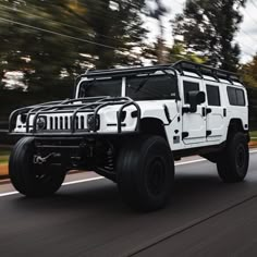 a white jeep is driving down the road