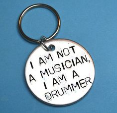 a metal keychain that says i am not a musician, i am a drummer