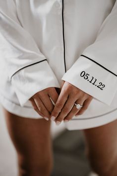 a close up of a person wearing a white shirt and black lettering on their sleeves