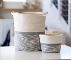 two baskets sitting on top of a white table