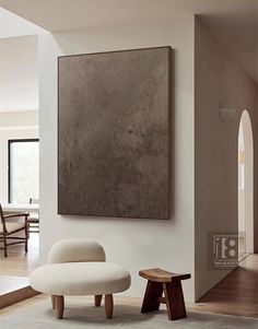 a living room with a large painting on the wall and two stools in front of it