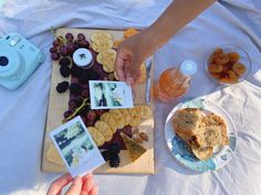 a person cutting up some food on top of a wooden board next to other foods