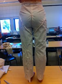 a woman standing on top of a table next to a pair of scissors and paper