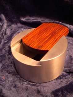 a wooden object sitting on top of a purple cloth