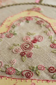 a close up of a piece of cloth with flowers on it and a heart shaped border