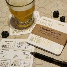 a glass of beer sitting next to some dices on a table with other items around it