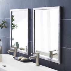 two mirrors on the wall above a sink in a room with blue walls and tile flooring