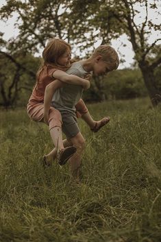 two children playing in the grass with each other