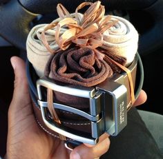 a person holding up a car steering wheel covered in blankets and cloths with ribbons on them