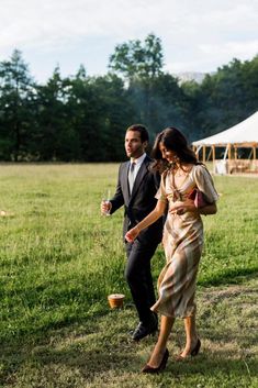 a man and woman are walking in the grass