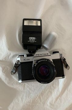 a camera and flash drive sitting on top of a white sheet