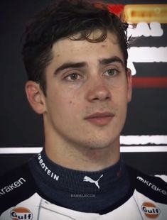 a close up of a person wearing a racing uniform