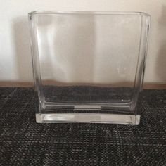 a clear vase sitting on top of a carpeted floor