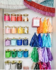 there are many different colors of yarn on the pegs in this craft room wall