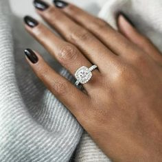 a woman's hand wearing a diamond ring