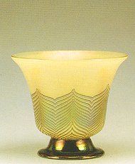 a yellow glass vase sitting on top of a table