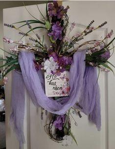 a purple wreath with flowers and a sign that says no more reason hanging on a door