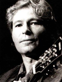 an old black and white photo of a man holding a guitar