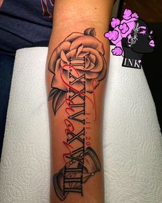 a woman's arm with a rose and some writing on the side of it