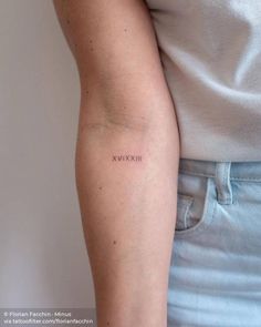 a woman's arm with the word xxvix tattooed on her left arm