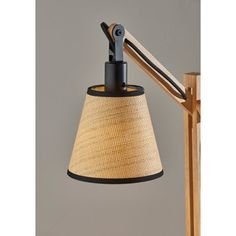 a lamp that is on top of a wooden stand with a light shade over it