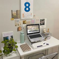 a laptop computer sitting on top of a white desk