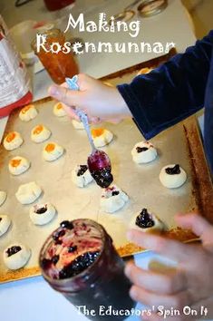 a person is making small desserts on a baking sheet with blueberries and raspberry sauce