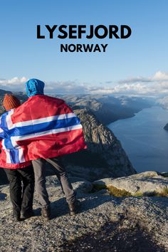 A couple of hikers with a Norwegian flag look out over the impressive Lysefjord, a fjord in southwest Norway. Fjords In Norway, Stavanger Norway, Norwegian Flag, Norway Fjords, Stavanger, The Well