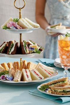 three tiered plates with sandwiches and drinks on them