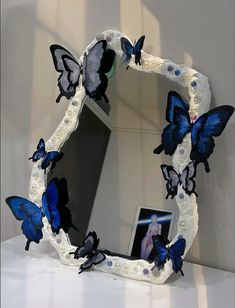 a mirror that has some blue butterflies on it and is sitting on a counter top