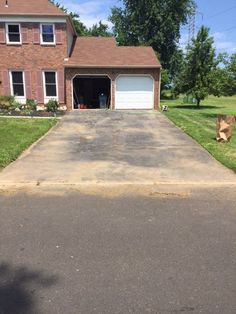 an empty driveway in front of a brick house