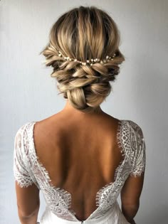 the back of a woman's head with braids and pearls in her hair