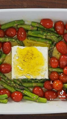 asparagus, tomatoes and eggs in a white dish