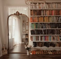 a room filled with lots of books on top of a book shelf next to a mirror