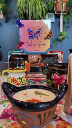 a table topped with lots of vases filled with different types of flowers and butterflies