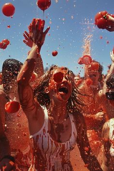 a group of people throwing tomatoes into the air