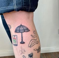 a woman's leg with tattoos on it and an umbrella