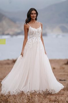 a woman in a wedding dress standing on the beach