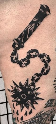 a man's arm with tattoos and chains on it