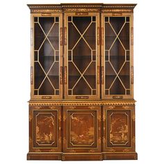 an antique bookcase with two doors and three drawers, painted in gold on the front