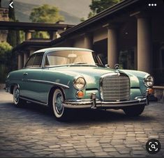 an old green car parked in front of a building