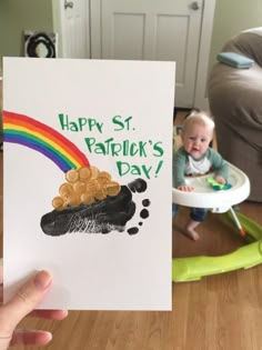 a baby in a highchair holding up a card that says happy st patrick's day