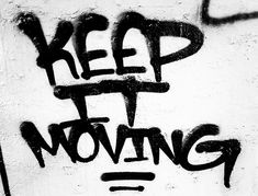 graffiti written on the side of a white wall reads keep it movin't